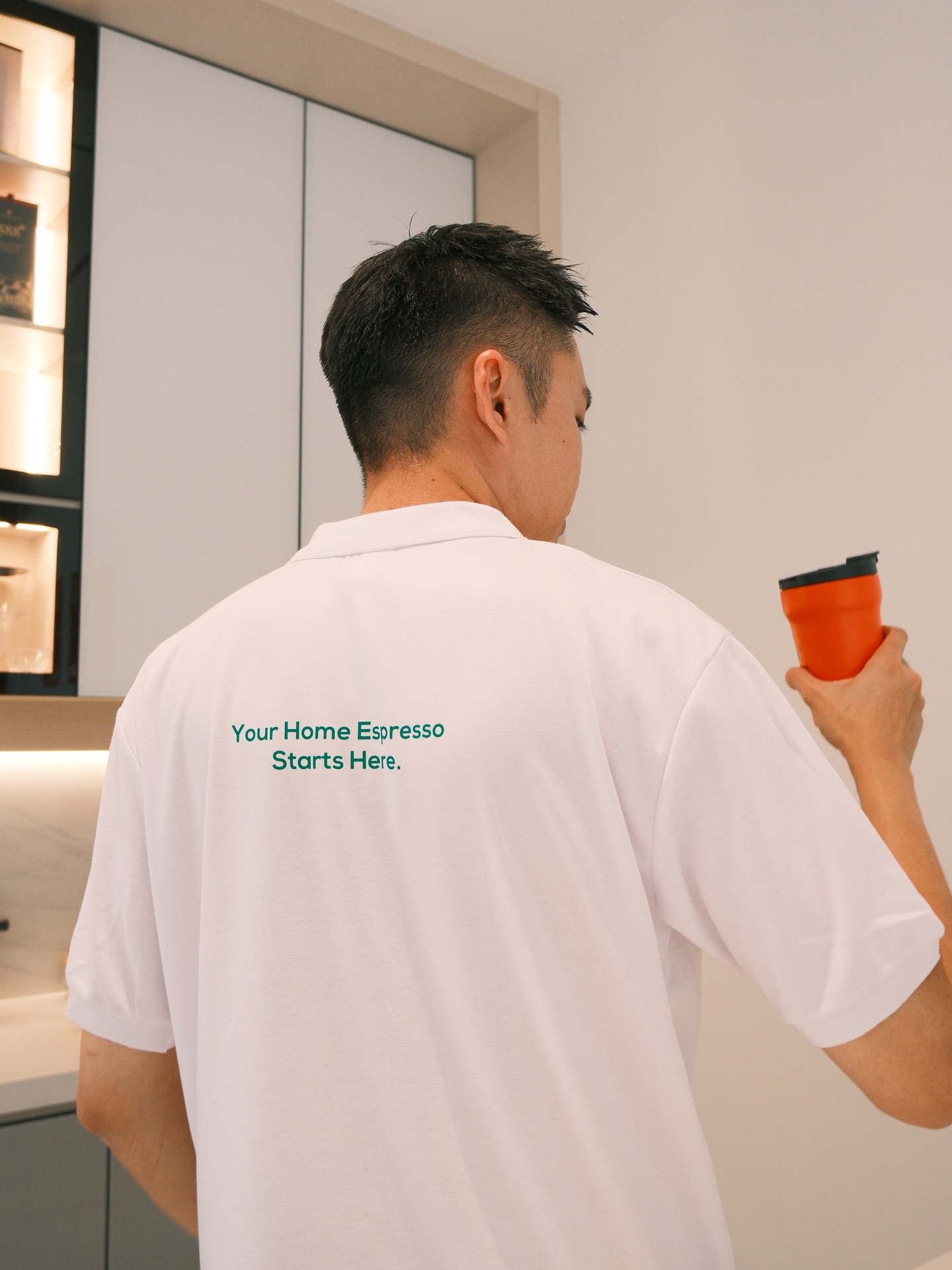 A ZuZu Coffee team member holding a cup in a warm studio setting.