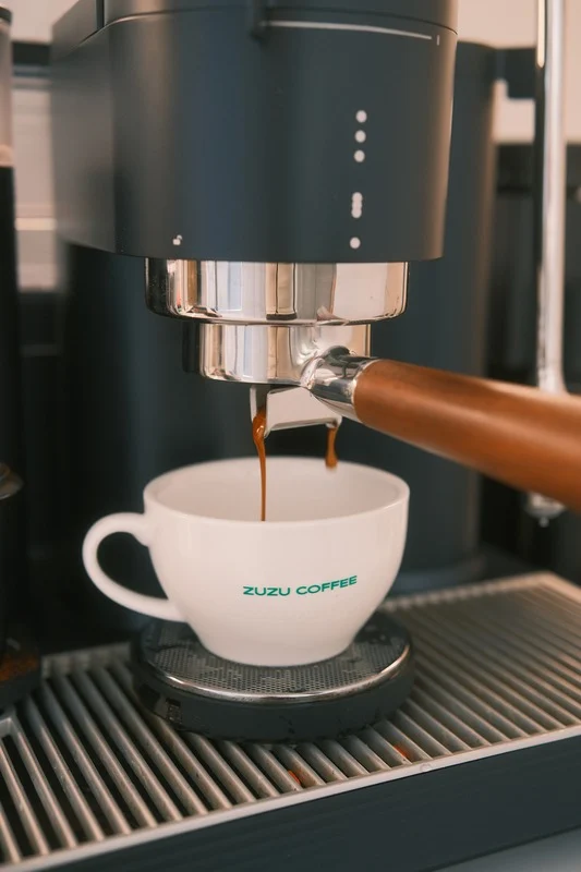MERAKI espresso extraction into a measuring cup.