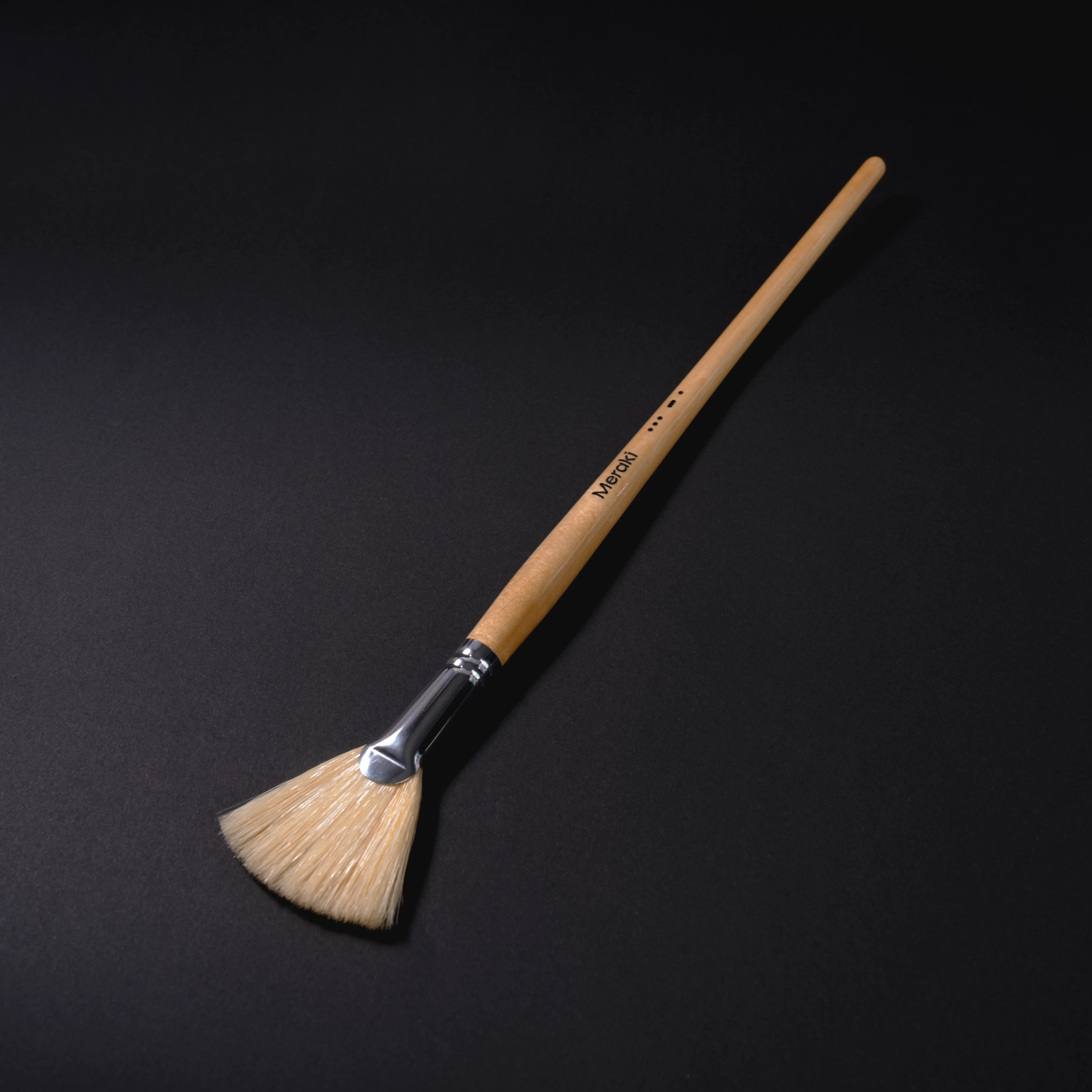 Coffee brush product on a dark background.