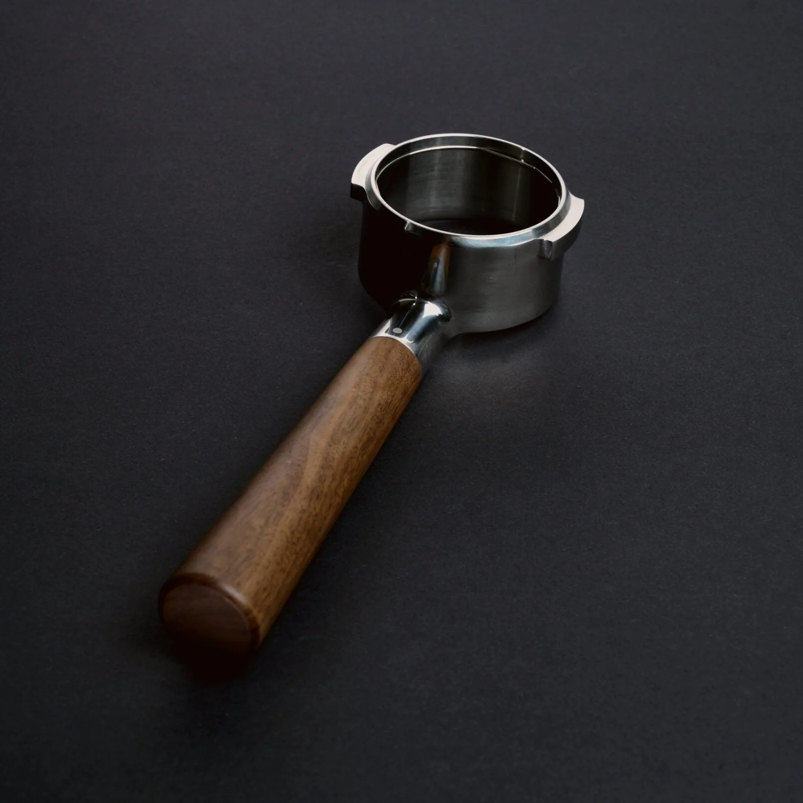 Bottomless portafilter with a wooden handle.